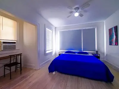 a bedroom with a blue bed and a desk at Stylish Miami retreat-Edgewater in Miami