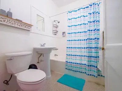 a bathroom with a toilet and a sink and a shower curtain at Stylish Miami retreat-Edgewater in Miami