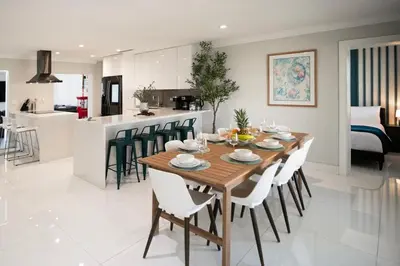 a kitchen and living room with a wooden table and chairs at Olympia LUX House 4BR, Heated POOL, BBQ, BAR in Miami
