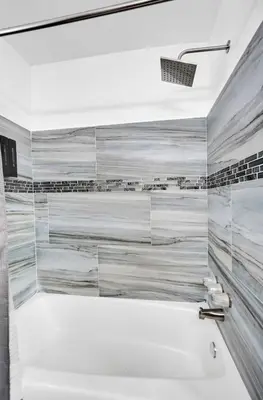 a bath tub in a bathroom with marble walls at Charming 3 bedroom getaway house in Hollywood in Hollywood