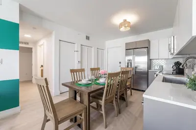 a kitchen and dining room with a table and chairs at Event-Ready 2BR 2BA Near Stadium & Beach includes Parking and Washer and Dryer in Hallandale Beach