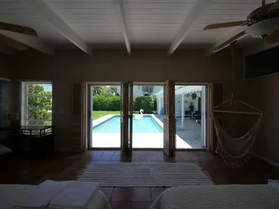 a bedroom with a door open to a swimming pool at 3BD Tropical Luxe Stay with Pool, Gameroom and Grill in Fort Lauderdale