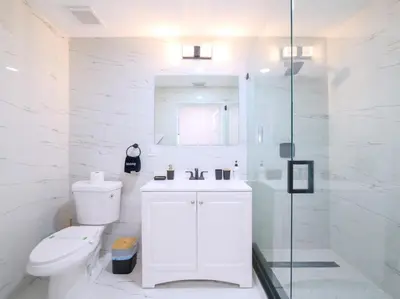 a white bathroom with a toilet and a glass shower at Dania Beach 3-bedroom house - Pool,Parking,Grill in Dania Beach