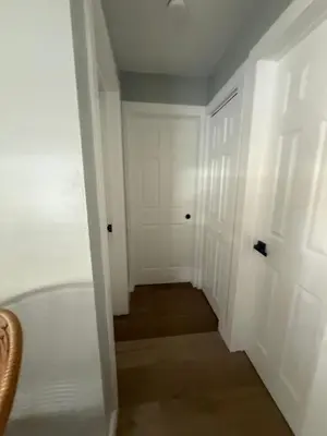 a hallway with a white door and a room with a floor at 2 Beach Units for 6 | Patio + Free Parking in Dania Beach