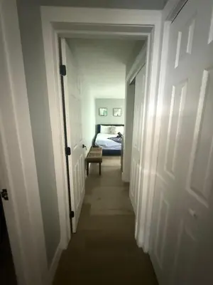 a hallway leading to a bedroom with a bed at 2 Beach Units for 6 | Patio + Free Parking in Dania Beach