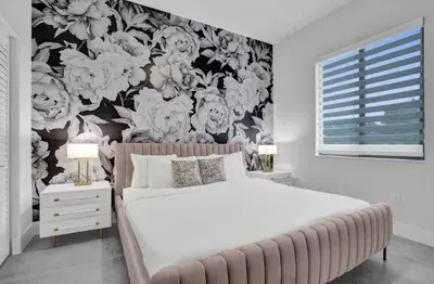 a bedroom with a large bed with a floral wallpaper at New Construction Villa HotTub Heated Pool Gameroom in Fort Lauderdale