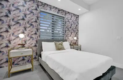 a bedroom with a bed and a large window at New Construction Villa HotTub Heated Pool Gameroom in Fort Lauderdale