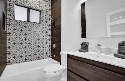 a bathroom with a tub and a toilet and a sink at New Construction Villa HotTub Heated Pool Gameroom in Fort Lauderdale