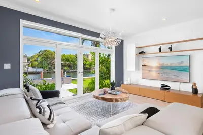 a living room with white furniture and a large window at Villa Asher - Waterfront with dock in Miami