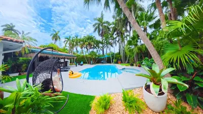 a swimming pool with a slide in a yard with palm trees at Villa Calma Hidden Tropical Gem with Gym and Pool in Hollywood