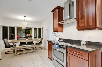 a kitchen with a table and a dining room at Villa Calma Hidden Tropical Gem with Gym and Pool in Hollywood
