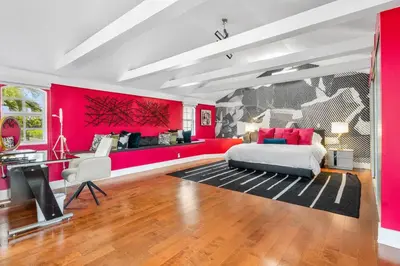 a bedroom with pink walls and a bed and a couch at Luxe 5BR 4BA I Heated Pool 10 Min to Beach I BBQ in Fort Lauderdale