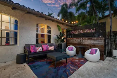 a patio with a couch and two ottomans at Luxe 5BR 4BA I Heated Pool 10 Min to Beach I BBQ in Fort Lauderdale