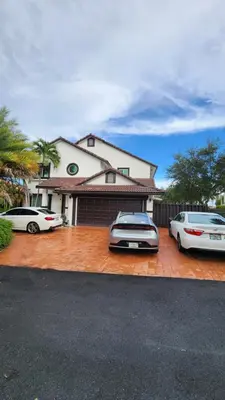 two cars parked in front of a house at Blue Loft305 in Hialeah