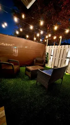 a backyard with chairs and a table and lights at Blue Loft305 in Hialeah