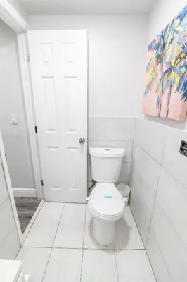 a bathroom with a white toilet in a room at Miami Shores Stay | Stylish Apt Minutes to Ocean in North Miami