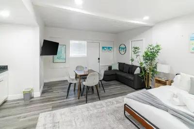 a bedroom and living room with a bed and a table at Miami Shores Stay | Stylish Apt Minutes to Ocean in North Miami