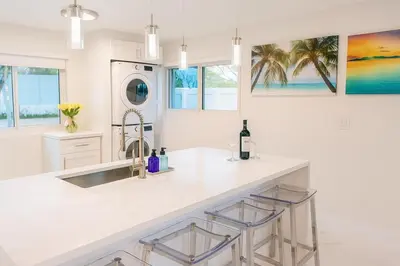 a white kitchen with a sink and a counter at Steps from Airport Hot Tub Bbq Boat Slip in Dania Beach