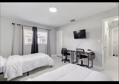 a bedroom with a bed and a desk with chairs at Homeaway Haven in Fort Lauderdale