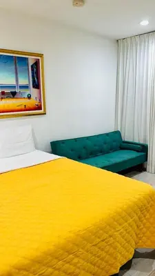 a bedroom with a yellow bed and a couch at OCEAN DRIVE-Beach Art Deco-2Queen,Cocina,Tv Wifi in Miami Beach