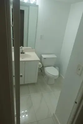 a white bathroom with a toilet and a sink at Ocean Reserve STR-01045 in Miami Beach