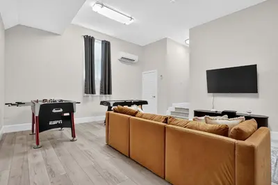 a living room with a couch and a flat screen tv at Hollywood Crest by Rove Travel - Home with Heated Pool in Hollywood