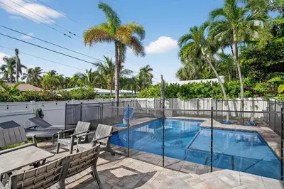 a swimming pool with a table and chairs and palm trees at Hollywood Crest by Rove Travel - Home with Heated Pool in Hollywood