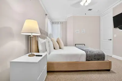 a white bedroom with a bed and a lamp at Hollywood Crest by Rove Travel - Home with Heated Pool in Hollywood