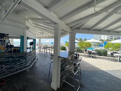 a pavilion with a table and chairs and tables at Sunny Isles Oceanfront Apartment for Two in Sunny Isles Beach