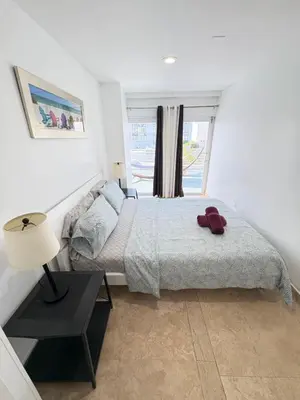 a bedroom with a bed and a lamp and a window at Incredible South Beach Penthouses with private terrace in Miami Beach