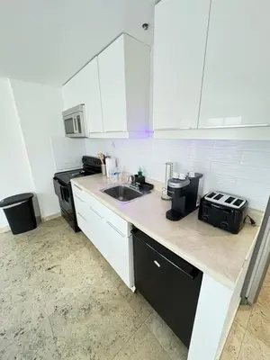 a white kitchen with a sink and a stove at Incredible South Beach Penthouses with private terrace in Miami Beach