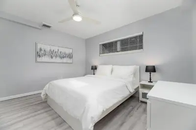 a white bedroom with a white bed and a window at The Residences at Lake Ridge Apt 1 in Fort Lauderdale