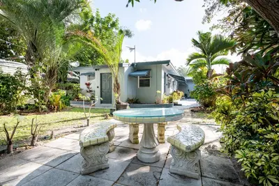 a patio with a table and chairs and a house at The Residences at Lake Ridge Apt 1 in Fort Lauderdale