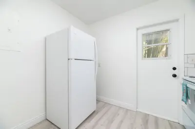 a white refrigerator in a white room with a window at The Residences at Lake Ridge Apt 1 in Fort Lauderdale