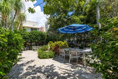 a patio with a table and an umbrella at SOFI NEW! King Bed, Beach, BBQ, Gated! in Miami Beach