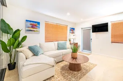 a living room with a couch and a table at SOFI NEW! King Bed, Beach, BBQ, Gated! in Miami Beach