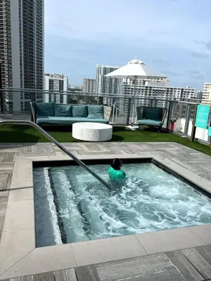 a person in a swimming pool on a rooftop at 39th Floor Oceanfront Penthouse with Pool & Gym in Hollywood
