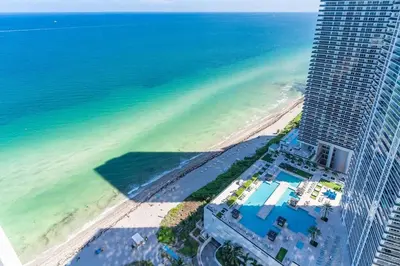 an aerial view of a beach and a tall building at 39th Floor Oceanfront Penthouse with Pool & Gym in Hollywood