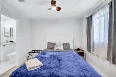 a bedroom with a bed with a blue blanket at Trendy Waterfront Pool Home Beach Casino Airport in Hollywood