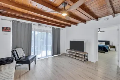 a living room with a tv and a couch at Trendy Waterfront Pool Home Beach Casino Airport in Hollywood