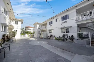 an empty courtyard of a white building with chairs at The Donovan in Miami Beach