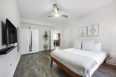 a white bedroom with a bed and a flat screen tv at The Donovan in Miami Beach
