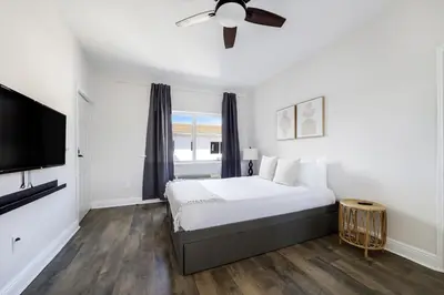 a white bedroom with a bed and a ceiling fan at The Donovan in Miami Beach