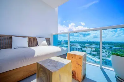 a bedroom with a bed and a large window at Amazing View 1 Hotel Corner Unit 2BR/2BA w Balcony in Miami Beach