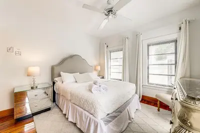 a white bedroom with a bed and a ceiling fan at Walk to Las Olas! Old Florida Oasis with Hot Tub in Fort Lauderdale