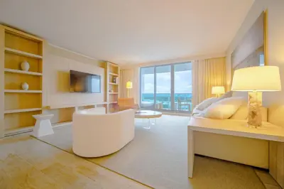 a bedroom with a bed and a chair and a television at Amazing View 1 Hotel Corner Unit 1BR/1BA w Balcony in Miami Beach