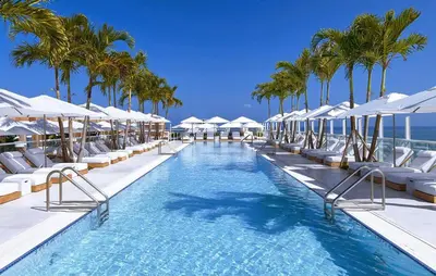 a swimming pool with lounge chairs and palm trees at Amazing View 1 Hotel Corner Unit 1BR/1BA w Balcony in Miami Beach