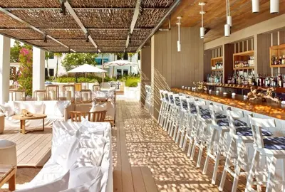 an outdoor patio with tables and chairs and a bar at Amazing View 1 Hotel Corner Unit 1BR/1BA w Balcony in Miami Beach