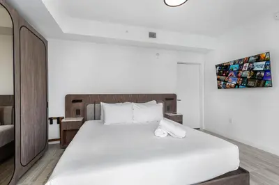 a bedroom with a large bed with white sheets at Condo at 72 Park - Miami Beach Area & Resort Facilities in Miami Beach