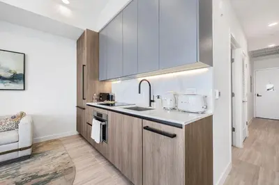 a kitchen with white walls and wooden cabinets at Resort & Beach - The Ideal Condo at 72 Park in Miami Beach